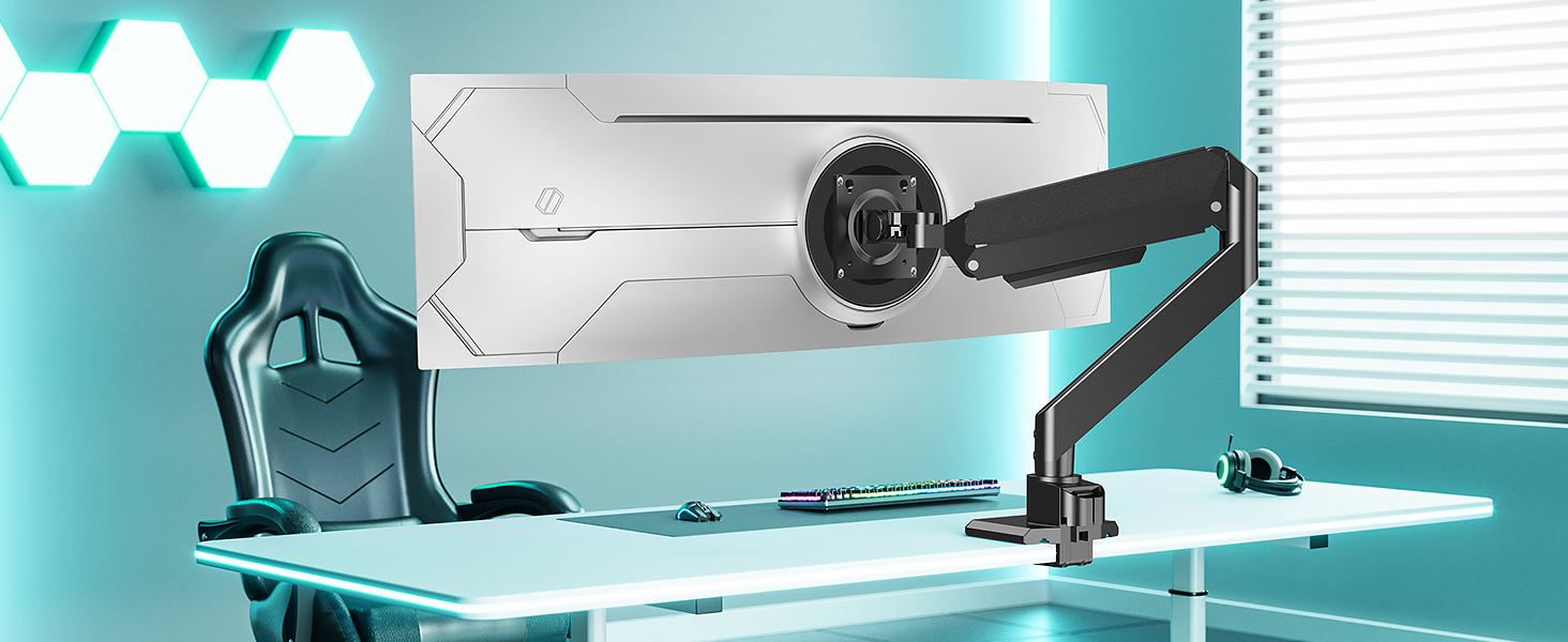 Modern home office setup with white desk, adjustable monitor arm, large microphone, and gaming chair. Teal walls and hexagonal light fixture visible in background.