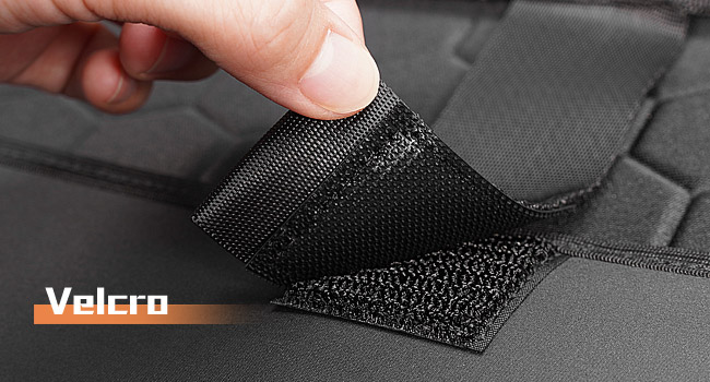 Close-up of black textured material with hexagonal pattern. Zipper visible along edge, suggesting a soft interior lining or padding.