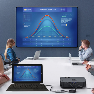 a group of people sitting around a table in front of a large screen.