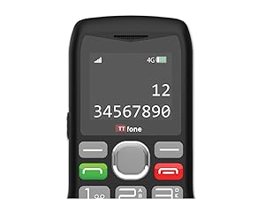 Basic mobile phone with large buttons being held in front of laptop keyboard, showing simple interface design suitable for easy use.