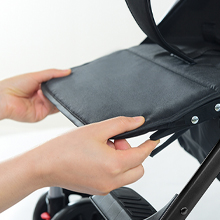 Close-up of hands interacting with what appears to be a black electronic device or surface.