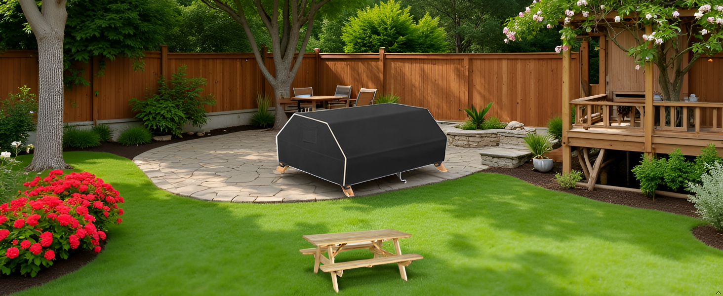A picnic table set up in a lush green garden with the product covering it.