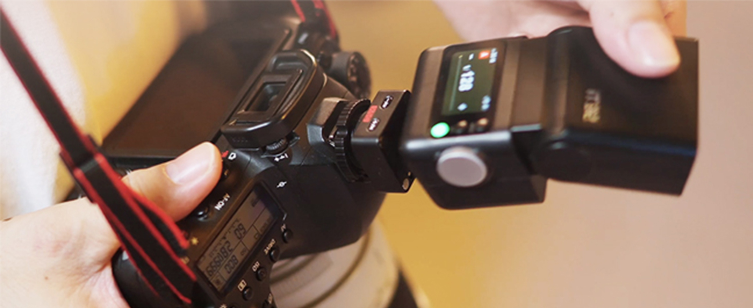 Close-up product photography of camera equipment or accessories in warm lighting, showing technical details and metallic components.