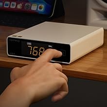 Digital display device showing LED numbers, placed on wooden surface. Multiple angles of what appears to be a smart home or electronic control unit.