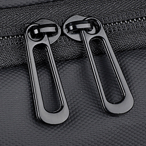 Close-up details of black textile material with reinforced stitching and zipper elements, showing durability features and construction.