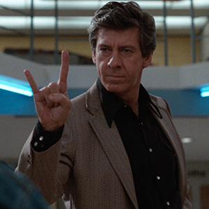 Dimly lit close-up portrait composition showing contemplative expression in dramatic lighting.