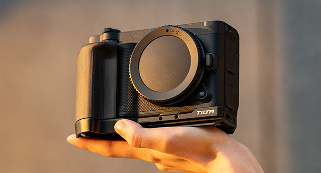 Camera cage or mounting frame shown in transparent 3D rendering against dark background with copper-toned lighting effects.