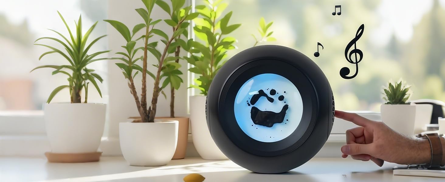 Black circular speaker or audio device with musical note symbol, displayed on wooden surface with decorative plants in white pots in background.