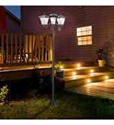 Nighttime park scene with two illuminated street lamps lighting a path near a wooden bench surrounded by trees and foliage.