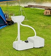 Grey portable toilet or camping toilet positioned on grass with orange tent visible in background. Square-shaped with solid construction and side handles