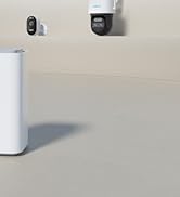 Home security setup featuring white router or hub device with mounted camera and additional security component on wall.