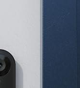 Partial view of a black camera or security device lens visible in the bottom right corner against a gray background.