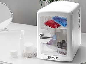 Text reads "DUOSONIC". White compact countertop mini refrigerator with transparent front door displaying red and blue storage containers inside, designed for personal cooling needs.