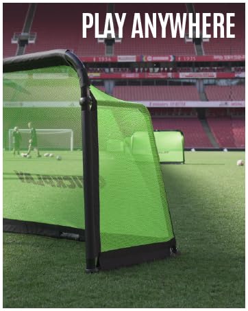 Green portable soccer goal on a stadium field. Text 'PLAY ANYWHERE' visible. Stadium seats in background.