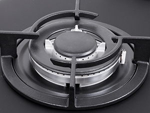 Close-up of metal latch or buckle mechanism on gray circular base, photographed against dark background. Metal fastening component detail.