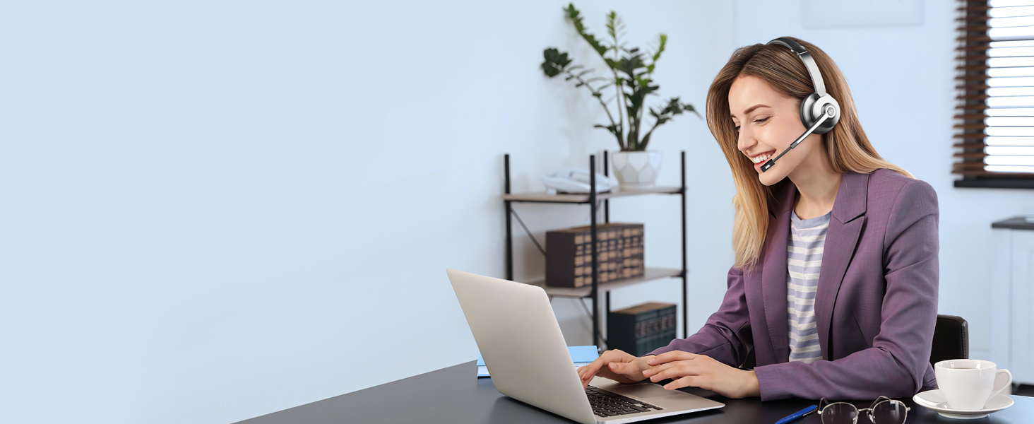 Wireless headset worn by person using laptop. Demonstrated for hands-free communication in home office setting.