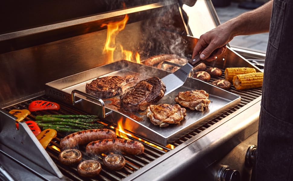 Outdoor cooking scene with hands grilling meat and vegetables on open flame campfire, demonstrating food preparation over fire.