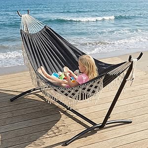 Striped hammock with stand shown on wooden deck by beach. Multiple views demonstrate hammock in use and freestanding position.