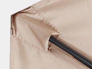 Close-up view of beige textured fabric or material surface with subtle folds and a dark circular element visible in the upper portion.