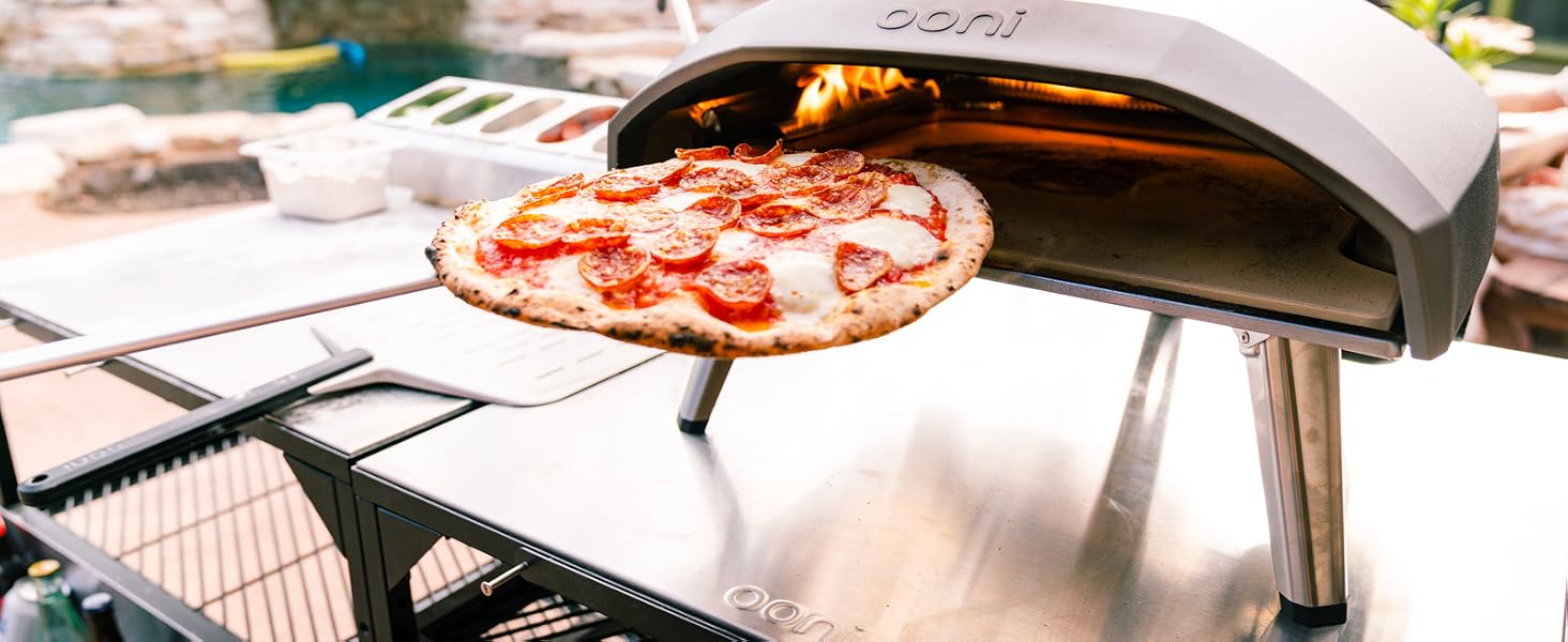 a pizza being cooked in an outdoor pizza oven.