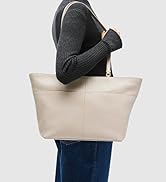 Black crescent-shaped shoulder bag with curved strap worn by person in white shirt and pleated skirt. Structured handbag with smooth finish displayed in side profile.