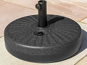 Black umbrella base stand with round weighted foot and vertical support pole on tiled surface.