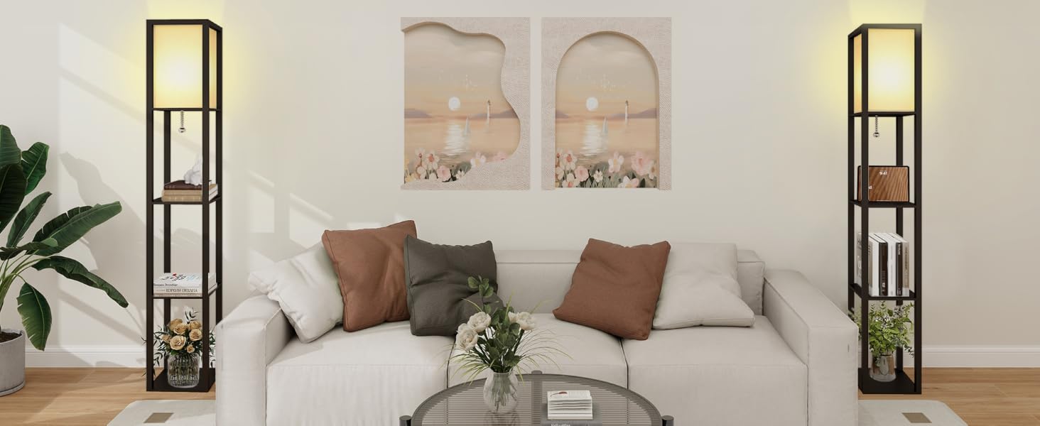 Modern living room featuring a light gray sectional sofa, floor lamps with shelving, abstract wall art, and a circular coffee table.