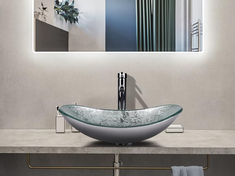 Modern bathroom vanity featuring an oval-shaped, glass vessel sink with a silver faucet, illuminated mirror, and stone countertop.