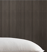 Close-up partial view of what appears to be a pillow or cushion surface against a gray background.