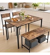 Dining table set with black metal frame and gray top, paired with matching bench and chairs on wooden floor, decorated with place settings and flowers.