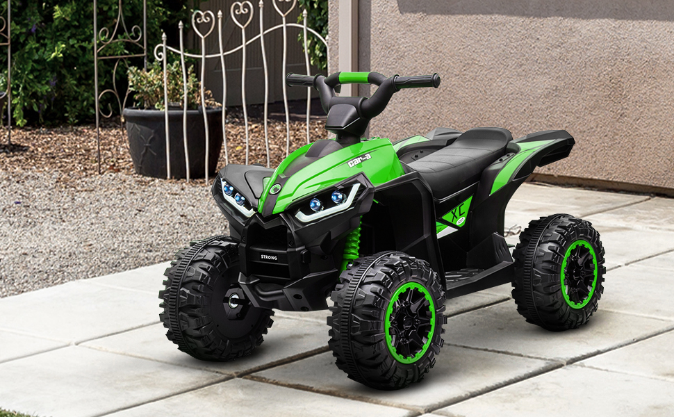 Bright lime green and black children's ride-on ATV toy vehicle with four wheels parked on outdoor concrete surface with fence and landscaping visible in background.