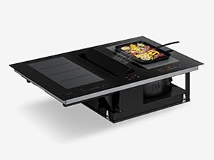 Black modular cooktop/cooking surface with dual cooking zones, digital control panels, and ventilation grid sections integrated into center unit.