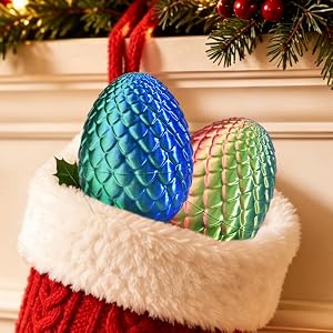 Iridescent rainbow-gradient quilted bowl-shaped containers holding colorful wrapped candies. Christmas setting with green wreath, red ornaments, wrapped gift box, and scattered candies on wooden surface.