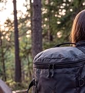Text reads "Pack It All". Adult and child on mountain rocky terrain wearing backpacks during golden hour sunset with mountain landscape background.