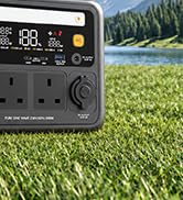 Compact digital device with yellow and black exterior panel displayed next to green grass field reference, showing portable measurement or monitoring equipment.