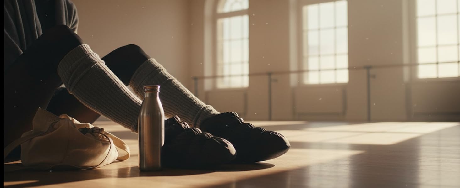 Person wearing black slip-on shoe standing indoors on polished floor with warm golden sunlight streaming through windows creating dramatic shadows.