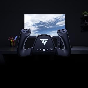Gaming controller mounted on dark wall above console, with illuminated monitor screen displaying blue sky landscape in home gaming setup.
